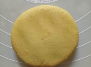 拿一个面团包入豆沙馅儿，搓圆，然后用手指压扁