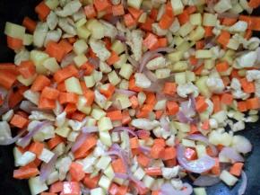 放入胡萝卜丁和土豆丁，炒几分钟