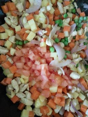 放入西红柿丁和豌豆炒几下