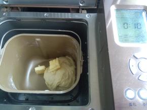 发酵好的面团撕成小块，投入面包机桶内，加入除黄油外所有材料，设置一个和面程序10分钟，暂停5分钟过后，加入黄油再次启动和面程序，设置15分钟。