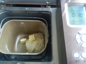 发酵好的面团撕成小块，投入面包机桶内，加入除黄油外所有材料，设置一个和面程序10分钟，暂停5分钟过后，加入黄油再次启动和面程序，设置15分钟。