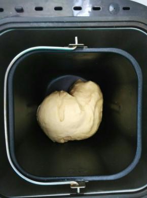 把加入黄油的面团放入面包桶内，启动和面程序两个，揉出膜