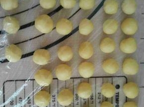 在二次发酵的过程中，做小熊耳朵。把剩余的面团1.5克一个，平均分成32个