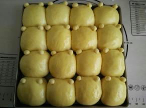 取出发酵好的面团，刷上全蛋液，再把小熊耳朵粘上