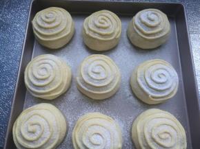 裱花袋剪小口，在面包表面均匀挤上黄油红薯酱。筛上面粉。