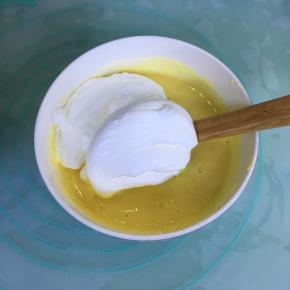 取三分之一的蛋白霜到蛋黄糊里，用刮刀翻拌均匀。