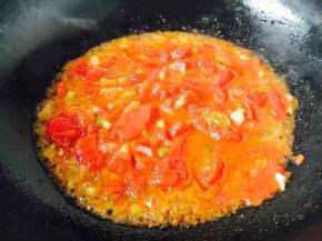 当佐料煸炒好了后，放入盘子中右侧的西红柿碎，中小火翻炒、熬制大约5分钟左右（这步不能偷懒），要把西红柿熬的软烂浓稠，这个酱汁是西红柿鸡蛋卤的灵魂所在。