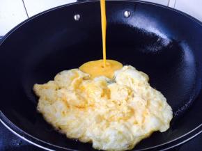 提前打散鸡蛋，鸡蛋里加一小勺水，调匀，锅里放适量的油，当油六成热时放入一部分鸡蛋液，鸡蛋立即成型，用铲子把成型的鸡蛋推到锅的一边，然后再倒入另外一部分鸡蛋液，鸡蛋液成型后，用铲子把所有鸡蛋滑散成碎片状，盛出备用。