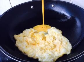 提前打散鸡蛋，鸡蛋里加一小勺水，调匀，锅里放适量的油，当油六成热时放入一部分鸡蛋液，鸡蛋立即成型，用铲子把成型的鸡蛋推到锅的一边，然后再倒入另外一部分鸡蛋液，鸡蛋液成型后，用铲子把所有鸡蛋滑散成碎片状，盛出备用。
