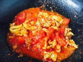 然后倒入炒好的鸡蛋，加1小勺酱油调色，加2小勺盐调味，翻炒均匀。