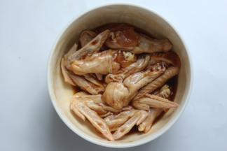 将鸡翅洗净控水后放入碗里，表面用小刀划几道口，这样腌才入味，再放入所有的调料