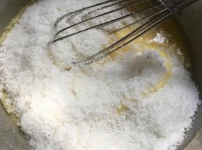 加入牛奶和全蛋液搅拌,再加入椰蓉搅拌均匀