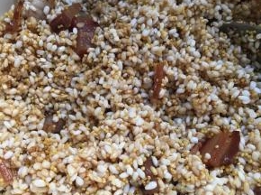 腊肉倒入米中，加生抽加盐搅拌均匀