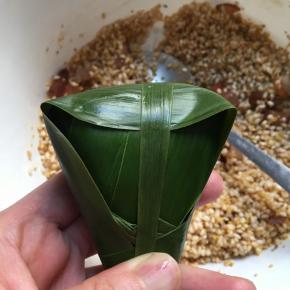 再取一个棕叶四周绕一圈，手捏紧不要松开