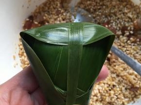 再取一个棕叶四周绕一圈，手捏紧不要松开