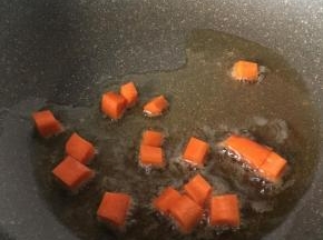 热锅放入油和萝卜丁翻炒