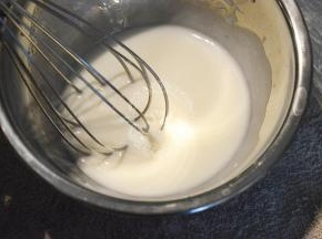 使用手动打蛋器搅打混合至完全混合乳化成为乳白色一体的状态