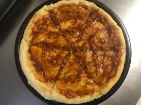 烤好的饼皮切成6-8块儿，抹上适量的自制披萨酱。