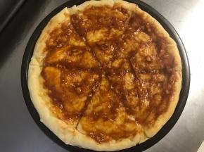 烤好的饼皮切成6-8块儿，抹上适量的自制披萨酱。