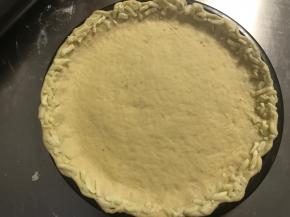 将边缘用手擀薄擀出一圈长边。取适量马苏里拉芝士粒贴在边缘。