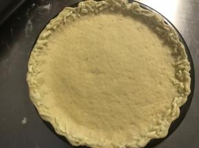 将边缘用手擀薄擀出一圈长边。取适量马苏里拉芝士粒贴在边缘。