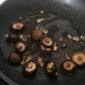 放入香菇，加入酱油、盐、半碗水，将香菇煮熟。