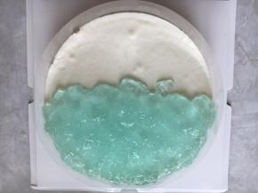 现在装饰蛋糕境面，用慕斯膜围在边缘，先把蓝色海水放上。