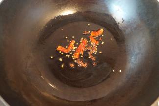 热锅内倒入芝麻油，小火炸香花椒和辣椒