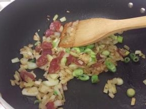 加入腊肠和葱头，炒一下