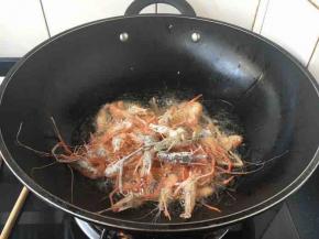开大火置锅，倒入适量的油，当油6成热时放入一半的小河虾，随后改中小火。
