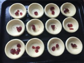 在蛋挞皮里放入蔓越莓果干