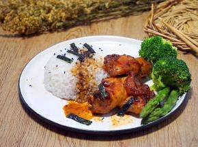 然后盛碗米饭盖在盘里，淋上照烧鸡腿的烧汁，剪入紫菜条，撒入黑芝麻，放入照烧鸡腿和蔬菜即可