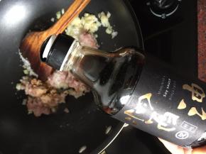 然后放入猪肉末、加入白砂糖、倒入又伊鲜鲜味酱油