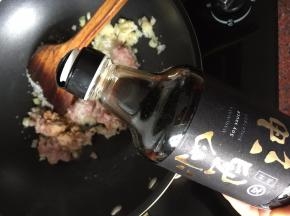 然后放入猪肉末、加入白砂糖、倒入又伊鲜鲜味酱油