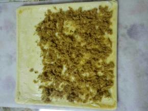 6、烤好后出炉震两下放凉，准备一张油纸，比蛋糕体长一点，底面朝上，抹上沙拉酱，撒上肉松(我自己炒的牛肉松)。