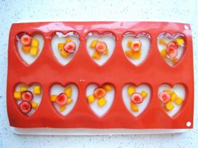 把透明的白凉粉液体倒入模具中，再撒些樱桃粒，入冰箱冷藏至凝固。