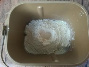 所有材料除黄油外，按照鸡蛋、牛奶、盐、糖（盐和糖对角放）、奶粉、高筋粉、最上面挖坑放酵母的顺序投入面包机桶内。
