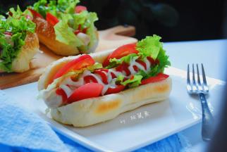 夹上洗净晾干的生菜，中间夹上考好的香肠，挤上沙拉酱，番茄酱，热狗面包就做好了