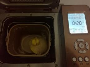 所有材料除黄油外全部投入面包桶，启动和面程序10分钟。时间到后暂停10分钟，再加入黄油，再次启动面包机和面程序20分钟.