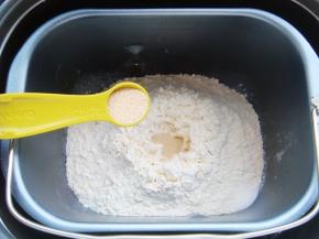 面粉中间挖小坑倒入酵母粉，在一角出倒入盐。（避免酵母粉与盐直接接触影响活性）