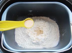 面粉中间挖小坑倒入酵母粉，在一角出倒入盐。（避免酵母粉与盐直接接触影响活性）