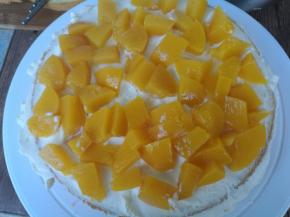 取最上面一片蛋糕坯，（底层蛋糕坯最平，最后再放）铺上一层打发好的奶油，加一层水果。