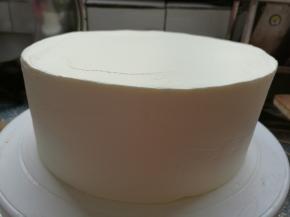 再盖上最后一片蛋糕坯，冰箱取出淡奶油抹平表面。