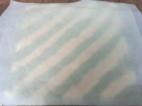 蛋糕晾至手温，取一张新油纸，盖在蛋糕上，翻面，揭去油布，再用揭开的油布盖在蛋糕上，再次翻过来。