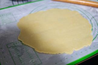 取出事先做好的派皮面团，分成两部分，其中一份用擀面杖敢成薄片