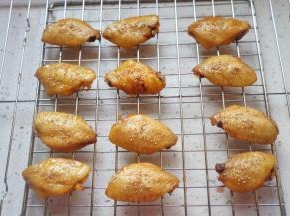 10分钟后取出鸡翅，刷一层蜂蜜水，撒少许芝麻