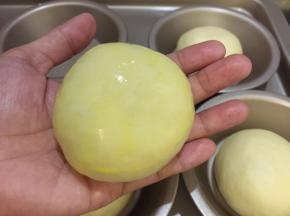 将面团再次搓圆，刷上蛋黄液