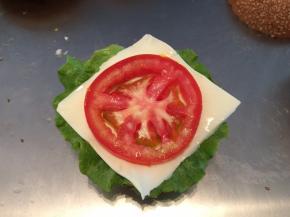 鸡胸肉用胡椒粉、盐、鸡精腌制2小时后下锅煎熟。面包胚+生菜叶+奶酪片+番茄+鸡肉+奶酪片+生菜组合起来（可加沙拉酱）