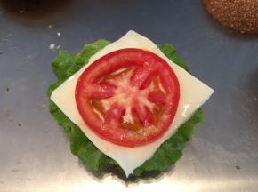 鸡胸肉用胡椒粉、盐、鸡精腌制2小时后下锅煎熟。面包胚+生菜叶+奶酪片+番茄+鸡肉+奶酪片+生菜组合起来（可加沙拉酱）