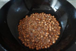 继续将油加热到8成热时关火，将花生米放进去复炸几秒钟。看到颜色变深马上捞出沥油。